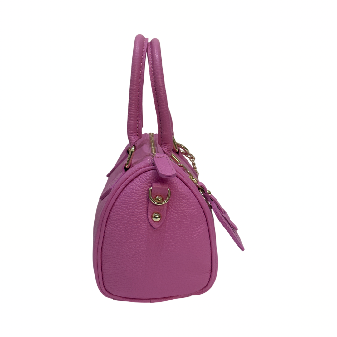 Side view of small pink leather tote bag with gold hardware.