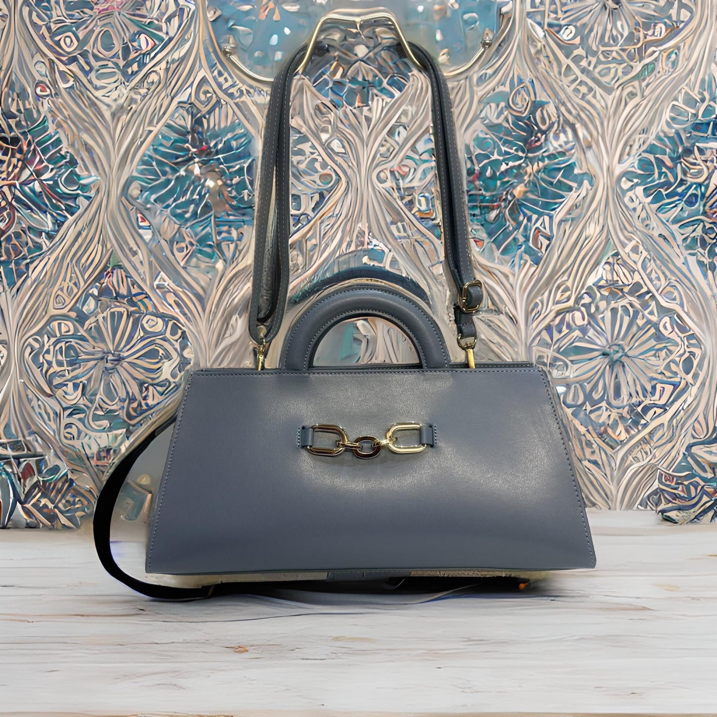 Cylinder shape leather tote bag with removable shoulder strap, featuring top handles and central zip closure.